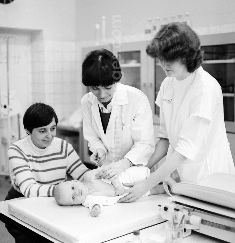 GDR image archive: Berlin - A mother is holding her baby at a check-up in the Children's Clinic in Klinikum Berlin-Buch in Berlin, the former capital of the GDR, the German Democratic Republic. The baby receives a vaccination (vaccination) as a preventive measure
