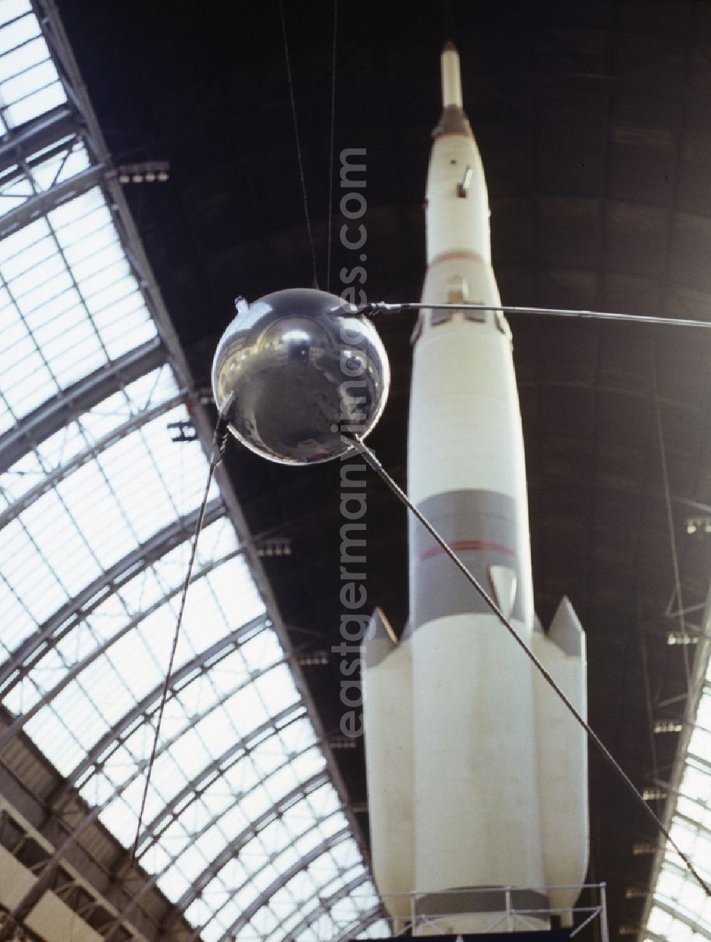 GDR photo archive: Moskau - Sputnik 1 on display at the All-Russia Exhibition Centre in Moscow in Russia. Sputnik 1 was the first artificial earth satellite. With it began in 1957, the space age. Behind this is the Saturn rocket-1