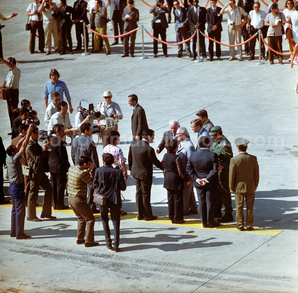 GDR picture archive: Santiago de Cuba - Der Staats- und Parteivorsitzende der DDR, Erich Honecker, wird auf dem Flughafen Santiago de Cuba von dem kubanischen Regierungschef Fidel Castro und weiteren Regierungsvertretern sowie der Presse in Empfang genommen. Honecker stattete vom 2