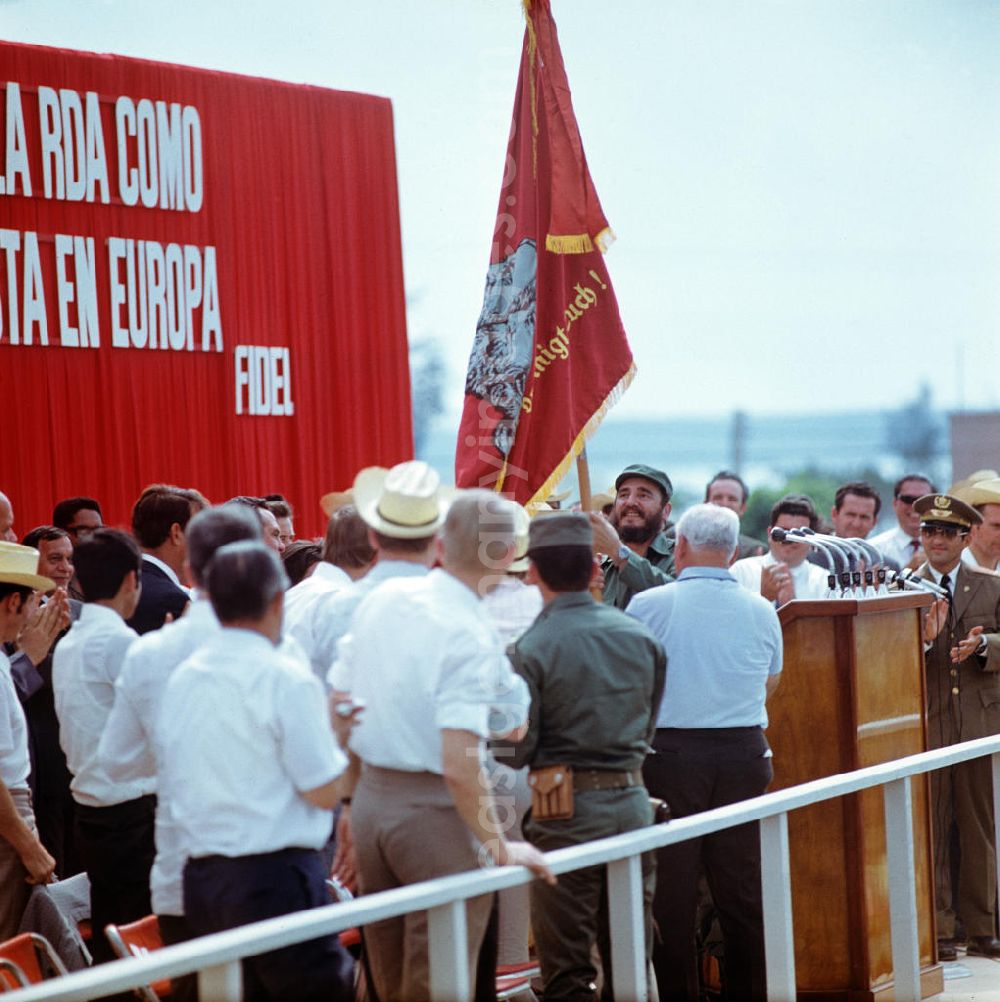 GDR photo archive: Cienfuegos - Bei einer Großkundgebung im kubanischen Cienfuegos anläßlich des Besuches des Staats- und Parteivorsitzenden der DDR, Erich Honecker, hält der kubanische Regierungschef, Fidel Castro, eine Rote Fahne mit Abbildern von Marx, Engels und Lenin sowie der Aufschrift Proletarier aller Länder vereinigt Euch! in die Höhe. Honecker stattete vom 2