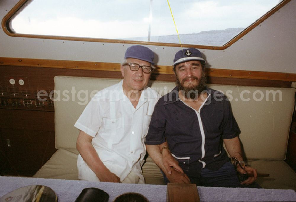 GDR photo archive: Havanna - Treffen von Erich Honecker und Fidel Castro auf einer Yacht in cubanischen Gewässern zu einem Angelausflug im Rahmen eines Staatsbesuches des DDR-Staatsratsvorsitzenden. Honecker und Castro sitzen nebeneinander in der Kajüte des Schiffs.