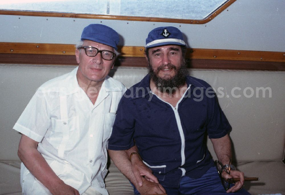 GDR picture archive: Havanna - Treffen von Erich Honecker und Fidel Castro auf einer Yacht in cubanischen Gewässern zu einem Angelausflug im Rahmen eines Staatsbesuches des DDR-Staatsratsvorsitzenden. Honecker und Castro sitzen nebeneinander in der Kajüte des Schiffs.