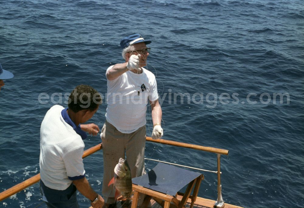 GDR picture archive: Havanna - Enduring fishing by GDR State Council Chairman Erich Honecker and the Secretary of the Central Committee of the Communist Party of Cuba Fidel Alejandro Castro Ruz on a state yacht as part of the cultural context of an official state visit to Havana in Cuba