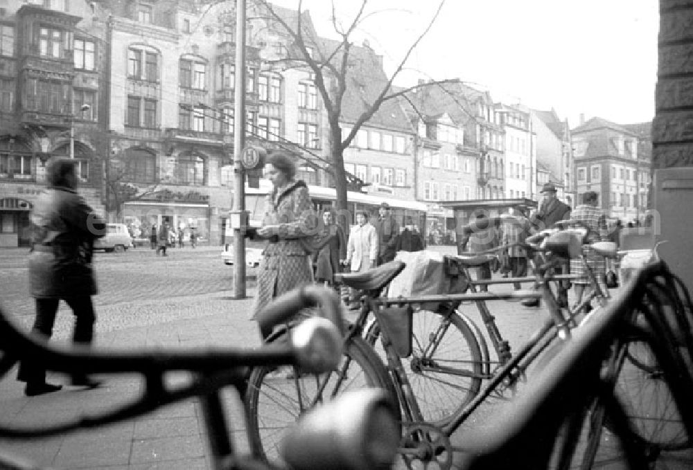 GDR picture archive: Erfurt - Blick auf Fahrräder auf Straßengeschehen. Passanten gehen auf Fussweg, Oberleitungs-Bus (O-Bus) steht an Bushaltestelle.