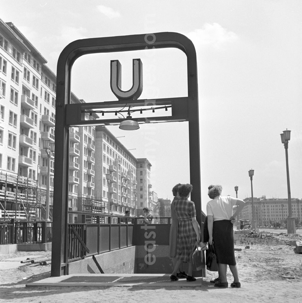 GDR picture archive: Berlin - View of the newly built Stalinallee (now Karl-Marx-Allee) in East Berlin on the territory of the former GDR, German Democratic Republic. Women talking at a not yet completed subway station entrance