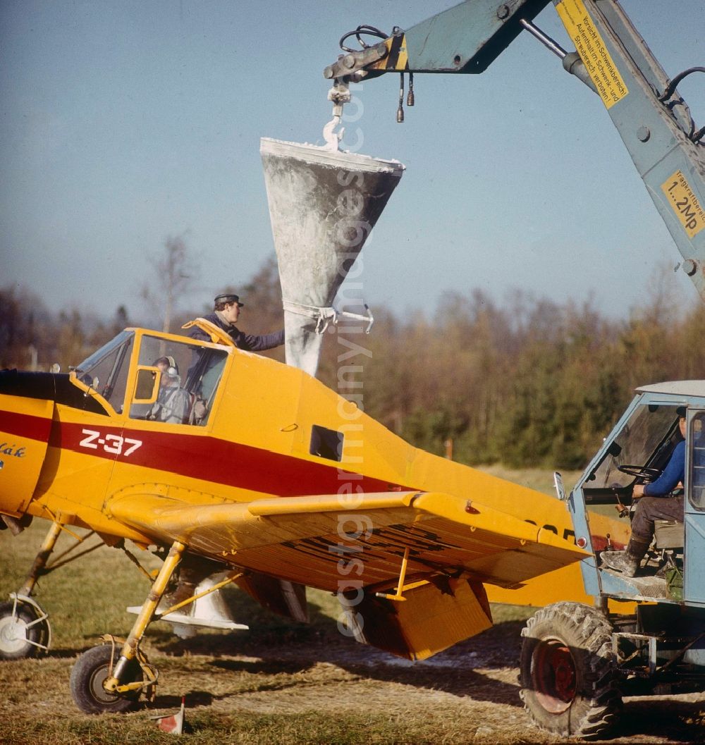 GDR image archive: Schlettau - Filling, maintenance and preparation for take-off of an agricultural aircraft of type Let Z-37 Cmelak with sign called DM-SOP of the agricultural flight operation of the state airline INTERFLUG on a strip of fields of an LPG - agricultural production cooperative to a spray flight for fertilization and pest control in the district Neu-Amerika in Schlettau at Erzgebirge in the state Saxony on the territory of the former GDR, German Democratic Republic