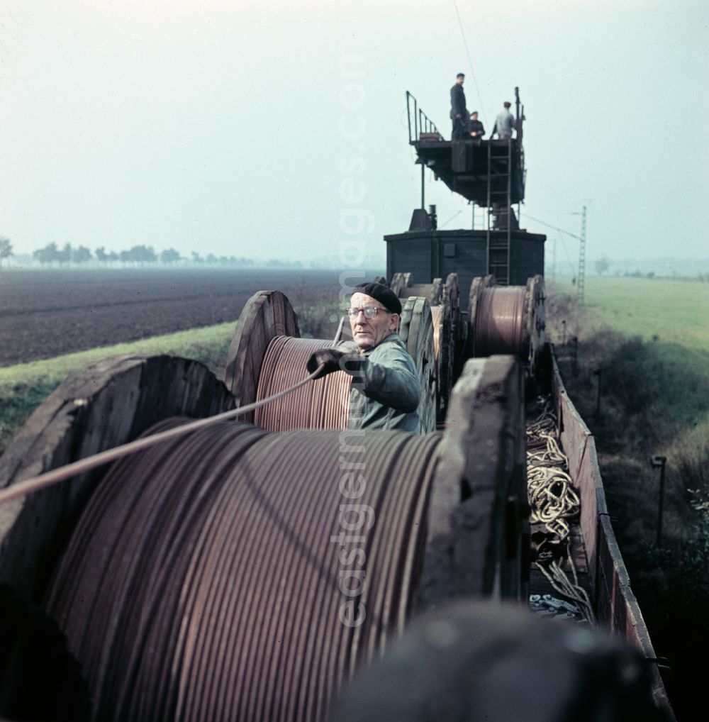 Halle (Saale): Work on the assembly of copper overhead lines - power lines on the rails and over the track systems on the railway line of the DR Deutsche Reichsbahn on the outskirts in Halle (Saale) in the state Saxony-Anhalt on the territory of the former GDR, German Democratic Republic