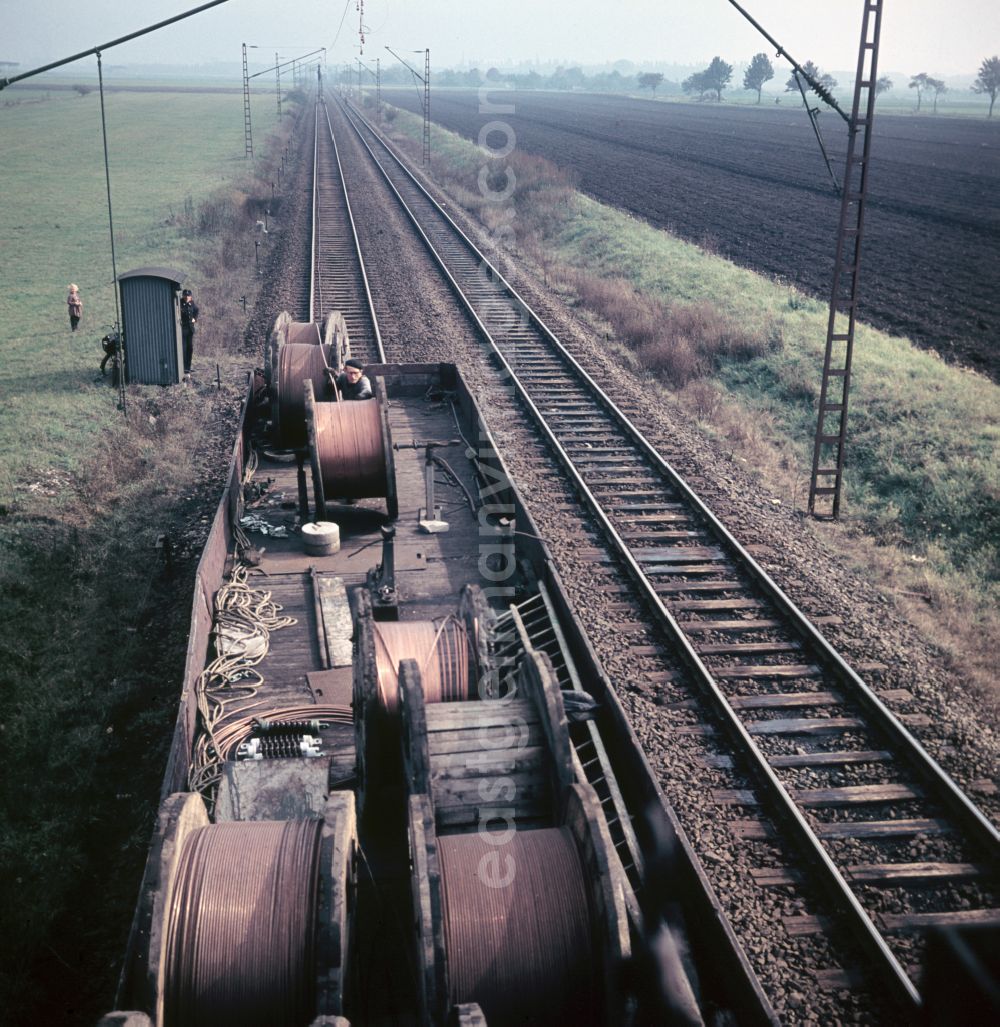 GDR image archive: Halle (Saale) - Work on the assembly of copper overhead lines - power lines on the rails and over the track systems on the railway line of the DR Deutsche Reichsbahn on the outskirts in Halle (Saale) in the state Saxony-Anhalt on the territory of the former GDR, German Democratic Republic