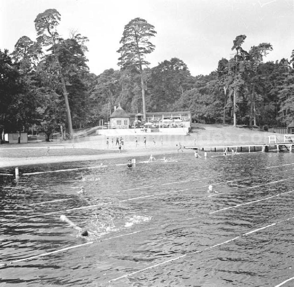 GDR picture archive: Dargun - Blick über das Wasser auf das Strandbad am Klostersee. Menschen schwimmen im Wasser.
