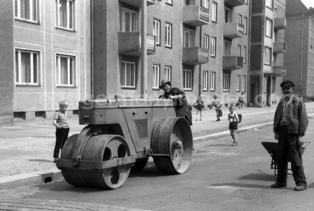 Berlin: Construction worker levels a road on a roller in Berlin Eastberlin on the territory of the former GDR, German Democratic Republic