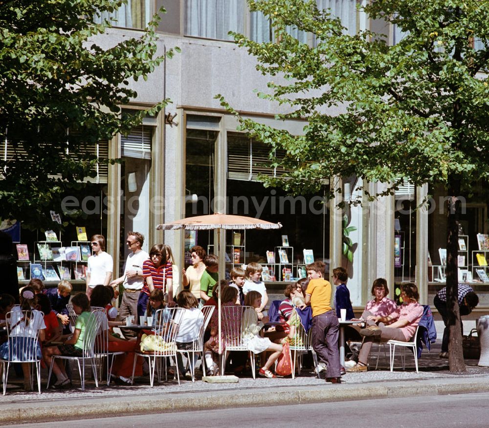 GDR picture archive: Berlin - Eine Kindergruppe sitzt in einem Café Unter den Linden in Berlin-Mitte, im Hintergrund die Auslagen einer Buchhandlung.