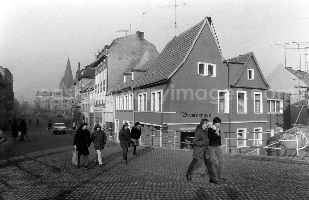 GDR image archive: Bernburg - Passanten laufen auf Straße, im Hintergrund Wohnhäuser sowie ein Blumenlanden mit der Aufschrift Blumenhaus an Hausfassade.