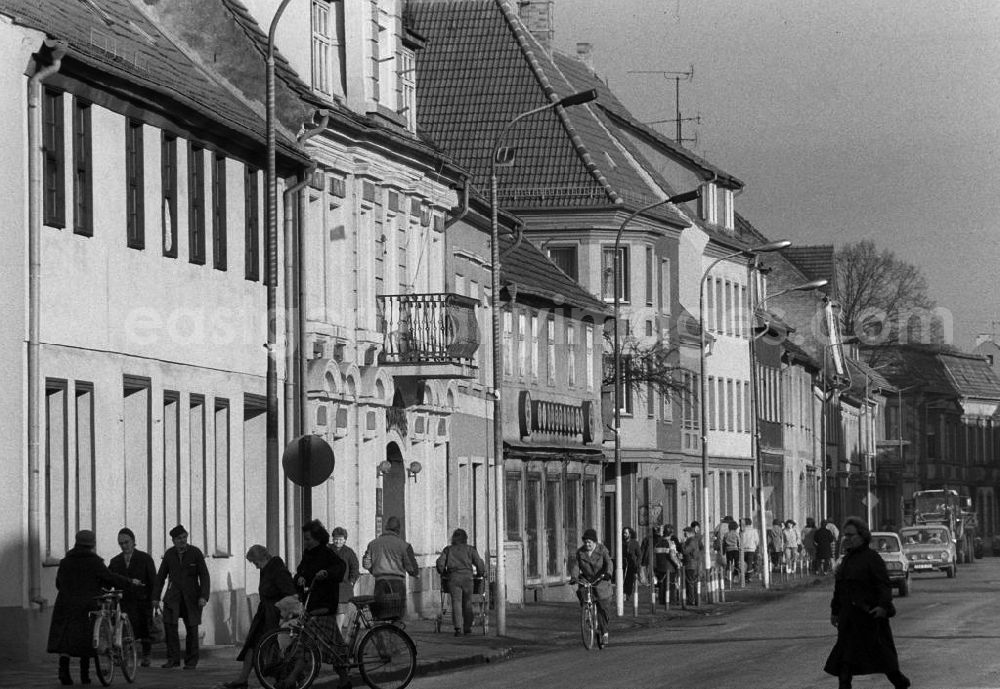 GDR image archive: Beeskow - Straßengeschehen entlang der Berliner Straße mit Rathaus. Passanten gehen auf dem Gehweg und überqueren die Straße, Autos fahren auf Straße.