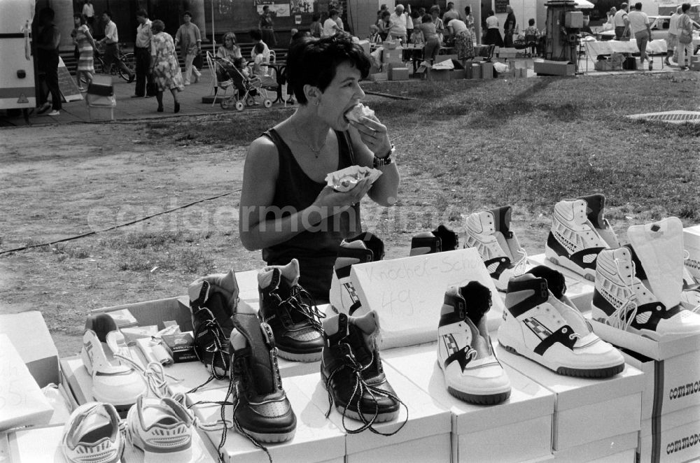 Berlin: A female street vendor sells at a stall on the Karl-Marx-Allee in Berlin - Friedrichshain sneakers of the brand Commodore