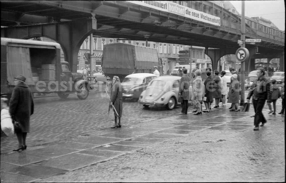GDR image archive: Berlin - Traffic policeman of the DVP German People's Police regulates the traffic situation with cars - motor vehicles and pedestrians on the road at Schoenhauser Allee crossing Eberswalder Strasse in the district of Prenzlauer Berg in the district Prenzlauer Berg in Berlin East Berlin on the territory of the former GDR, German Democratic Republic