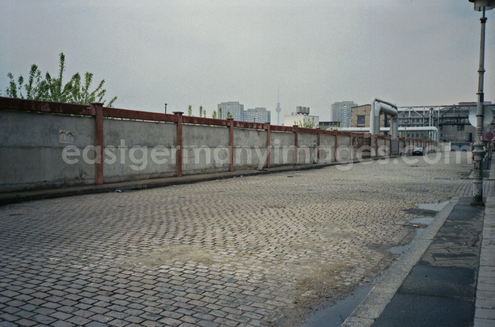 GDR image archive: Berlin - Road traffic and road conditions on a cobblestone street on an industrial area wall on Warschauer Strasse in the Friedrichshain district of Berlin East Berlin on the territory of the former GDR, German Democratic Republic