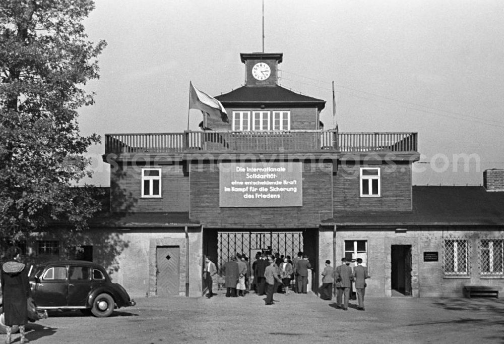 Buchenwald: Besucher betreten durch das Torgebäude das Gelände des ehemaligen Konzentrationslager Buchenwald. Über dem Tor hängt die Losung Die Internationale Solidarität - eine entscheidende Kraft im Kampf für die Sicherung des Friedens. Zwei Jahre später erfolgte die Einweihung als Nationale Mahn- und Gedenkstätte Buchenwald. In den 5