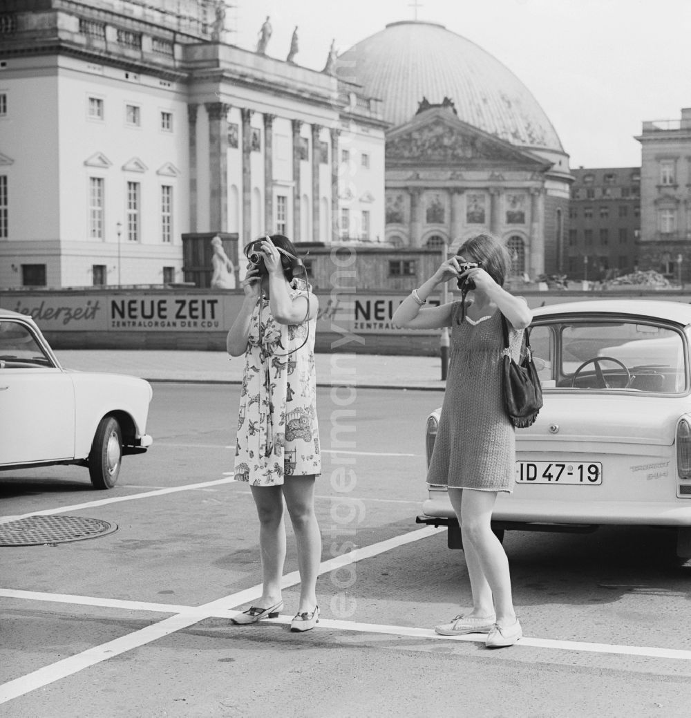 GDR image archive: Berlin - Mitte - Tourists while photographing on the boulevard Unter den Linden in Berlin - Mitte before the Bebelplatz. In Hintergrung the St. Hedwig's Cathedral