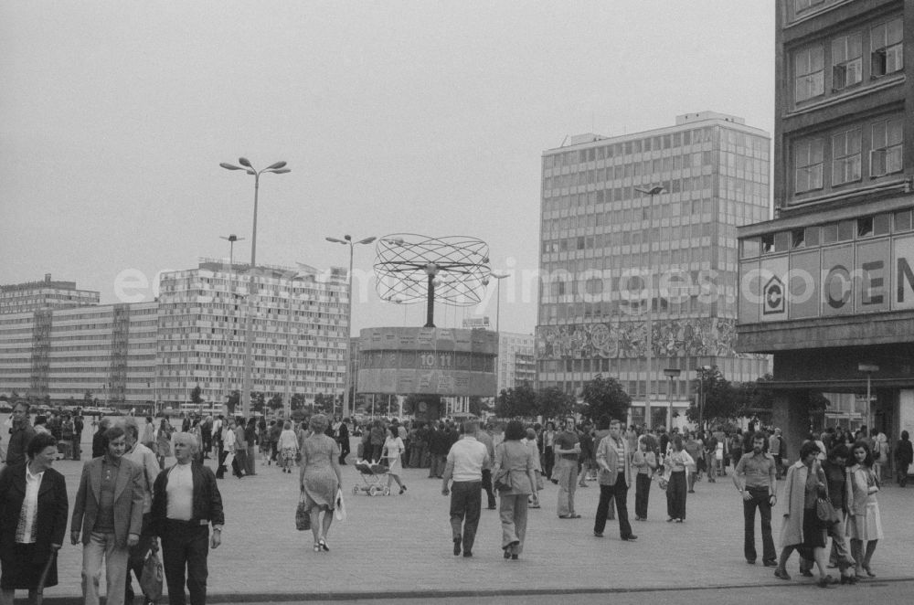 GDR photo archive: Berlin - Tourists and Berlin at the world clock on the Alexanderplatz in Berlin, the former capital of the GDR, the German Democratic Republic. In the right background is the house of the teacher