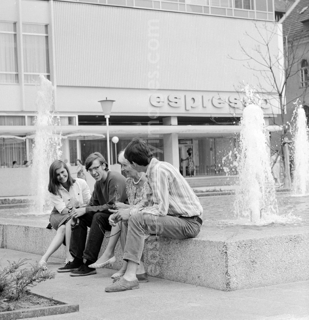 GDR photo archive: Berlin - Tourists sitting in front of the Hotel Unter den Linden / Lindencorso the fountain in Berlin, the former capital of the GDR, the German Democratic Republic