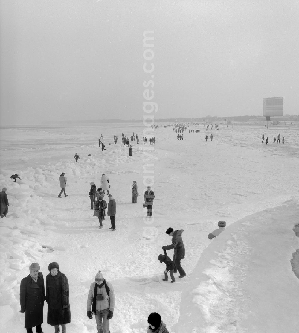 GDR photo archive: Warnemünde - Tourists walk on the frozen and snow-covered Baltic Sea in Warnemuende in the federal state Mecklenburg-Western Pomerania on the territory of the former GDR, German Democratic Republic
