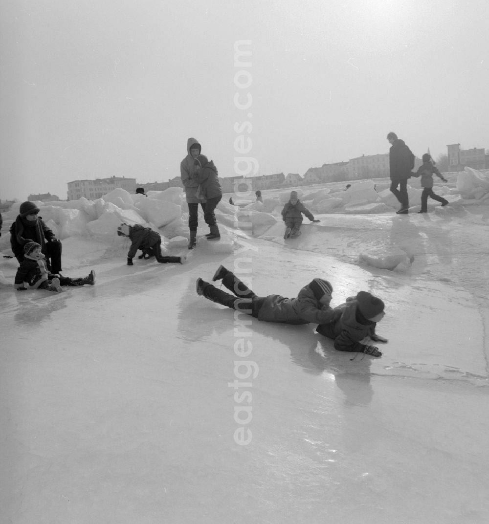 GDR photo archive: Warnemünde - Tourists walk on the frozen and snow-covered Baltic Sea in Warnemuende in the federal state Mecklenburg-Western Pomerania on the territory of the former GDR, German Democratic Republic
