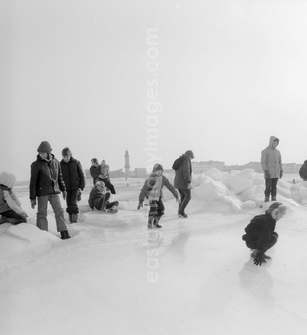 GDR picture archive: Warnemünde - Tourists walk on the frozen and snow-covered Baltic Sea in Warnemuende in the federal state Mecklenburg-Western Pomerania on the territory of the former GDR, German Democratic Republic