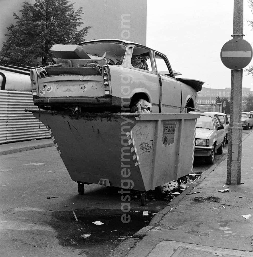 GDR photo archive: Berlin - A Trabant was disposed of in a bulky waste container on the side of a road in Berlin - Mitte