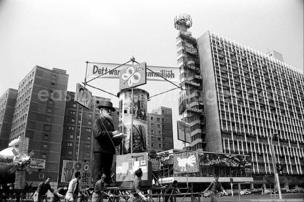 GDR photo archive: Berlin - Protest poster and banner slogan for May 1st mounted on pushcarts pushed by young FDJ members on the street at the intersection of Karl-Liebknecht-Strasse - Memhardstrasse in the Mitte district of Berlin East Berlin on the territory of the former GDR, German Democratic Republic