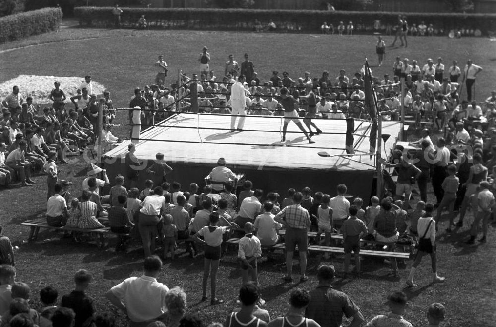 GDR picture archive: Leipzig - Gespannt schauen die großen und kleinen Zuschauer einem Boxkampf beim IV. Deutschen Turn- und Sportfest in Leipzig vom 1.-4.8.1963 zu.
