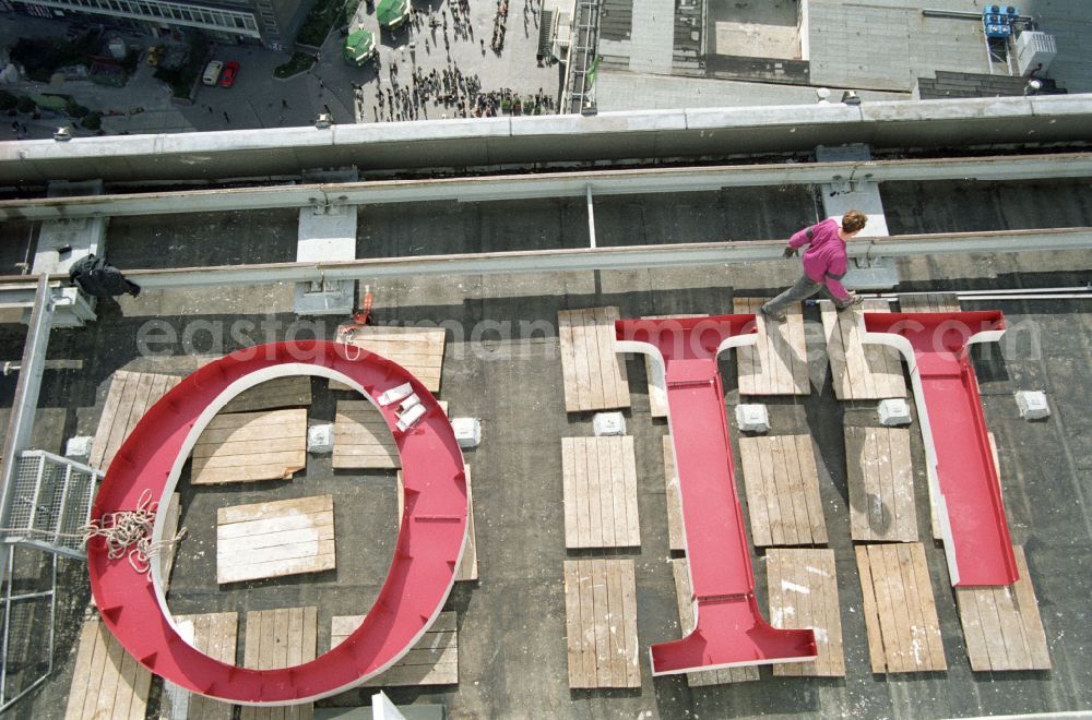 GDR photo archive: Berlin - Renaming work on the roof of the gastronomic facility of the hotel building from HOTEL STADT BERLIN to FORUM HOTEL on Alexanderplatz in the district Mitte in Berlin East Berlin in the area of ​​the former GDR, German Democratic Republic