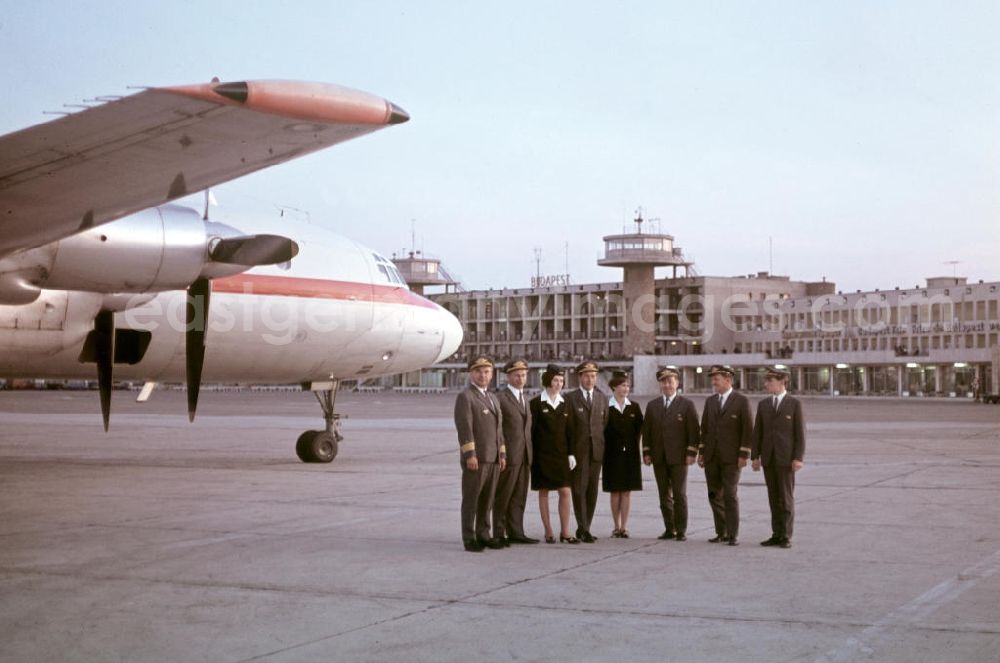 GDR image archive: Budapest - Eine Crew, Piloten und Stewardessen, der DDR-Fluggesellschaft Interflug steht vor dem Passagierflugzeug Iljuschin IL-18 auf dem Flughafen Ferihegy in der ungarischen Hauptstadt Budapest.