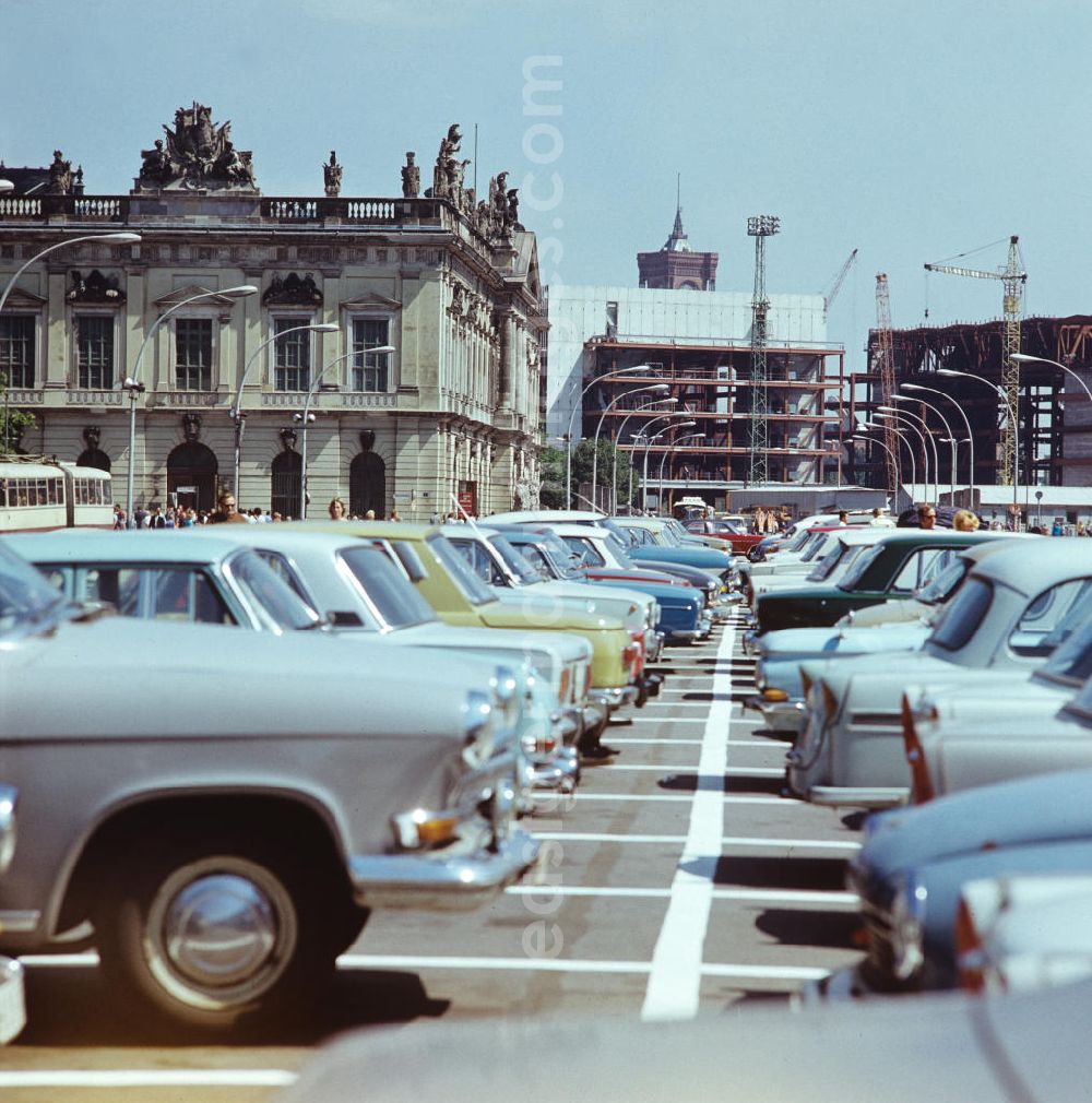 GDR picture archive: Berlin - Blick über die parkenden Autos auf dem Mittelstreifen Unter den Linden in Berlin-Mitte zum Zeughaus, dem noch im Bau befindlichen Palast der Republik (PdR) und der Spitze des Roten Rathauses.