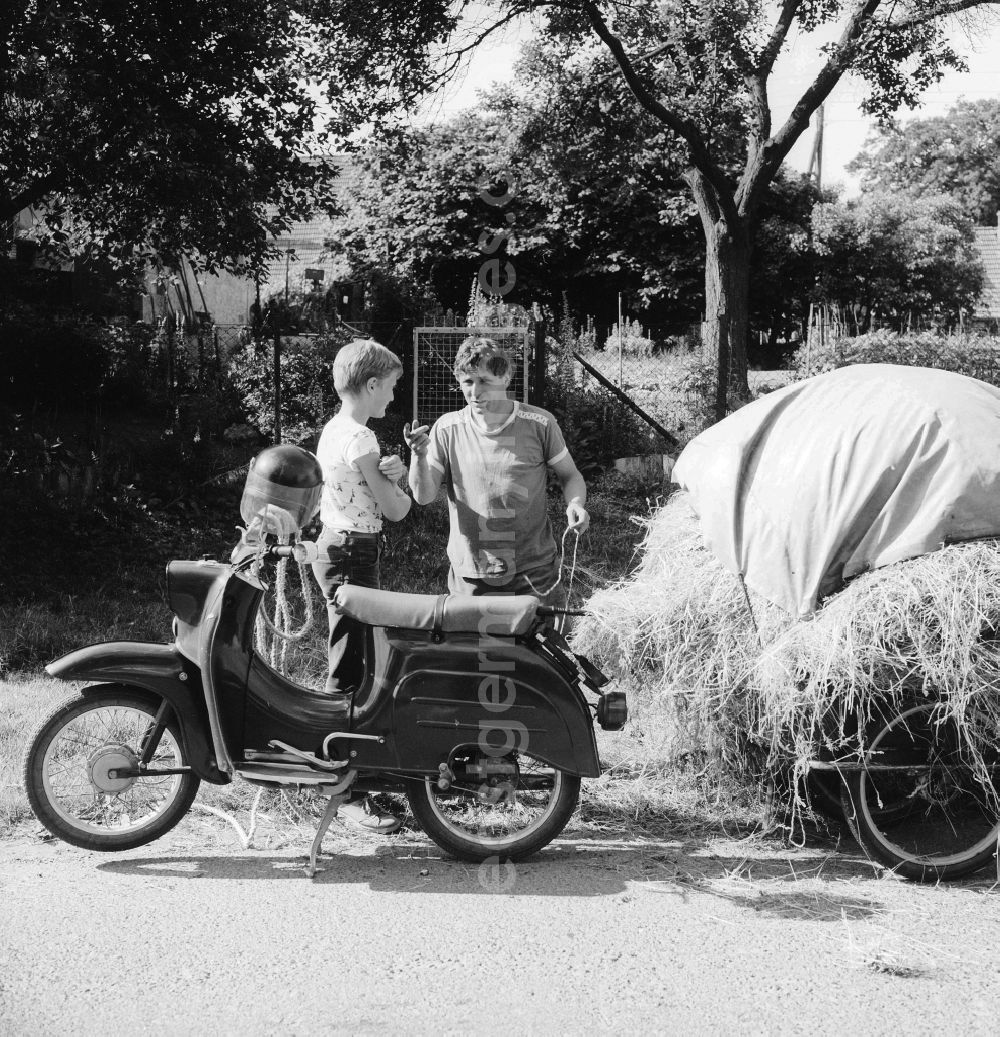 Schwerin: A father with his son advance on a motorcycle, the brand Swallow with follower, hay in Schwerin in the federal state Mecklenburg-West Pomerania in the area of the former GDR, German democratic republic
