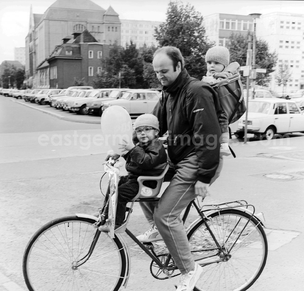 Berlin: Father with two children on a bicycle in Berlin, the former capital of the GDR, German Democratic Republic