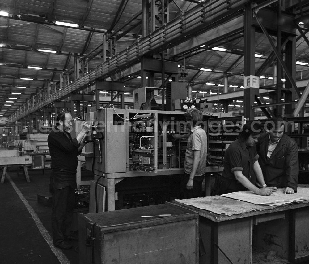 GDR photo archive: Berlin - Arbeiter während der Produktion von Werkzeugmaschinen in der VEB Berliner Werkzeugmaschinenfabrik (BWF) Marzahn. Zwei Arbeiter arbeiten an einer Maschine, zwei weitere stehen zusammen vor einer technischen Zeichnung.