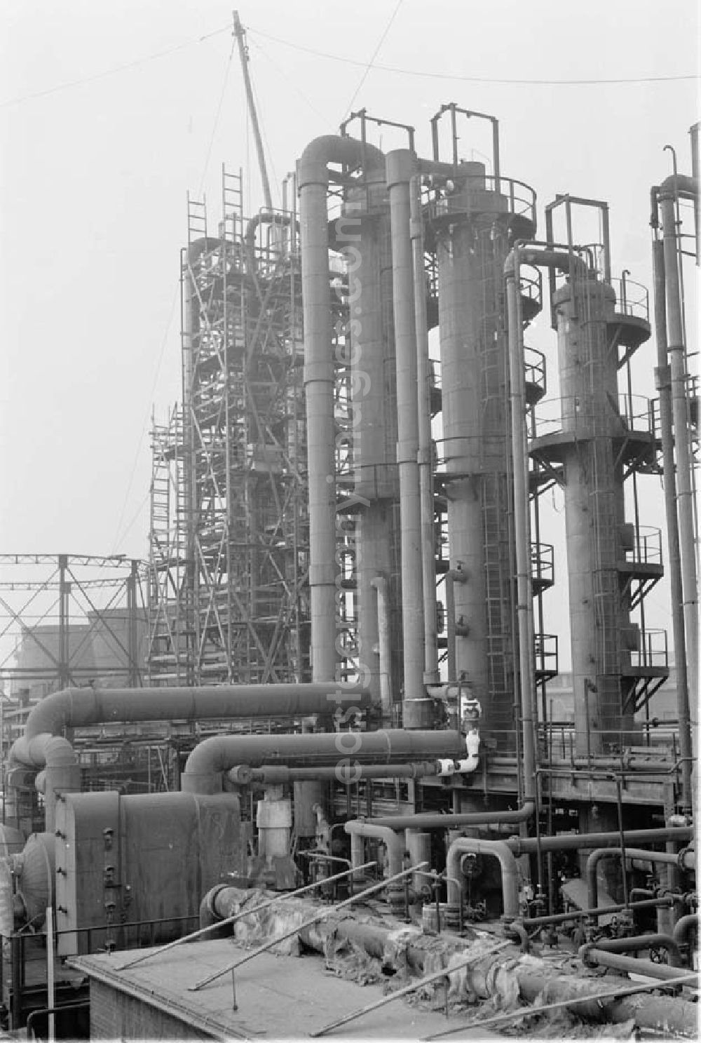 GDR image archive: Lützkendorf - Blick auf die Raffinerie VEB Mineralölwerk Lützkendorf. Schornsteine in Hintergrund in Baugerüst gehüllt.