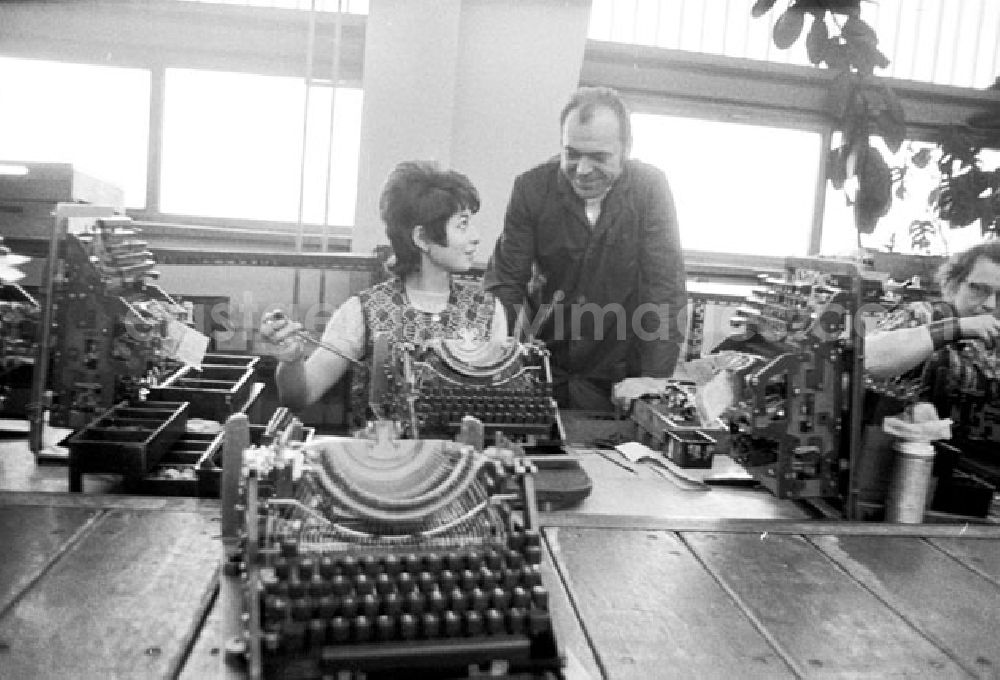 Erfurt: Arbeiterin sitzt an Schreibmaschine bei Montage, Vorarbeiter steht daneben im VEB Optima Büromaschinenwerk Erfurt.
