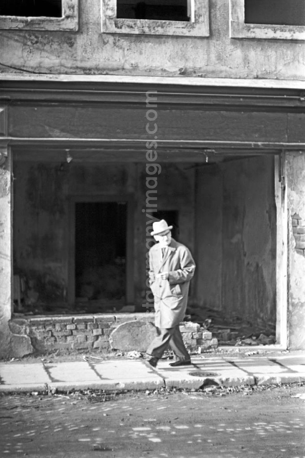 Leipzig: Ein Mann mit Zigarette geht während eines Spaziergangs an einem verfallenen Wohnhaus in Leipzig vorbei.