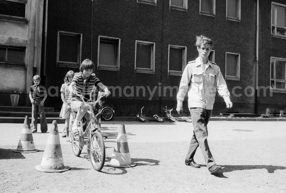 GDR picture archive: Berlin - Schoolgirls and schoolboys with the road safety education in the holiday's plays / hoard on the summer holidays in Berlin, the former capital of the GDR, German democratic republic. The holiday's plays were intended mainly for schoolboys first to the fourth class