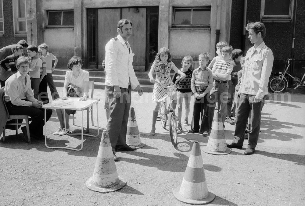 GDR image archive: Berlin - Schoolgirls and schoolboys with the road safety education in the holiday's plays / hoard on the summer holidays in Berlin, the former capital of the GDR, German democratic republic. The holiday's plays were intended mainly for schoolboys first to the fourth class