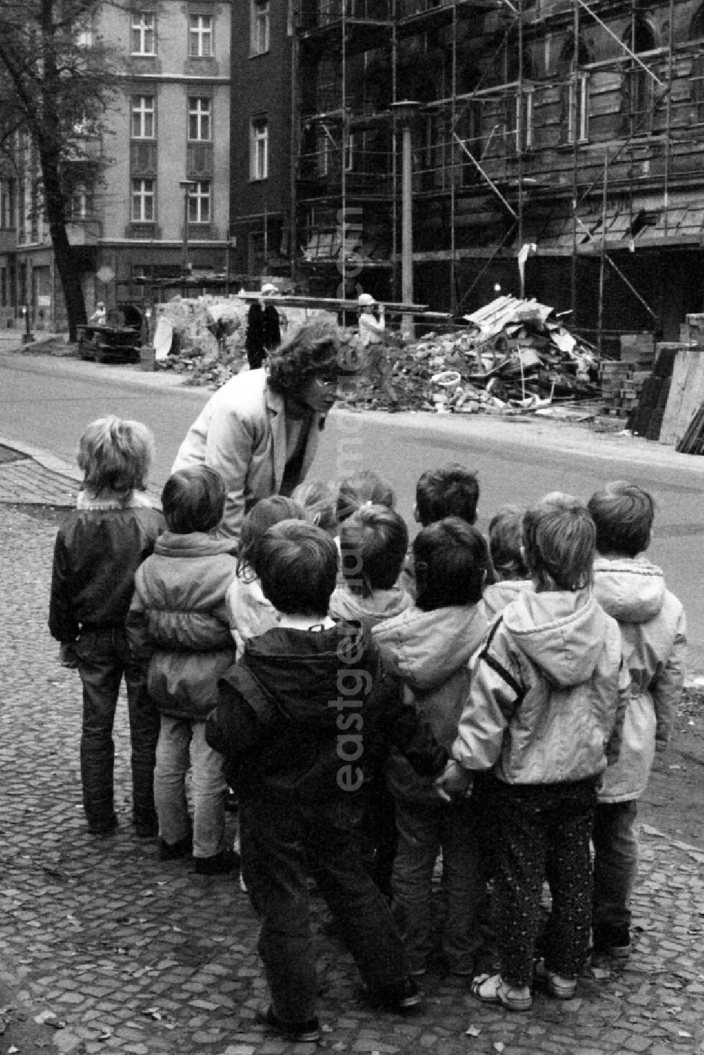 GDR image archive: Berlin - Traffic education kindergarten in Berlin Eastberlin on the territory of the former GDR, German Democratic Republic. Kindergarten teacher is standing together with children on a street, children are listening attentively