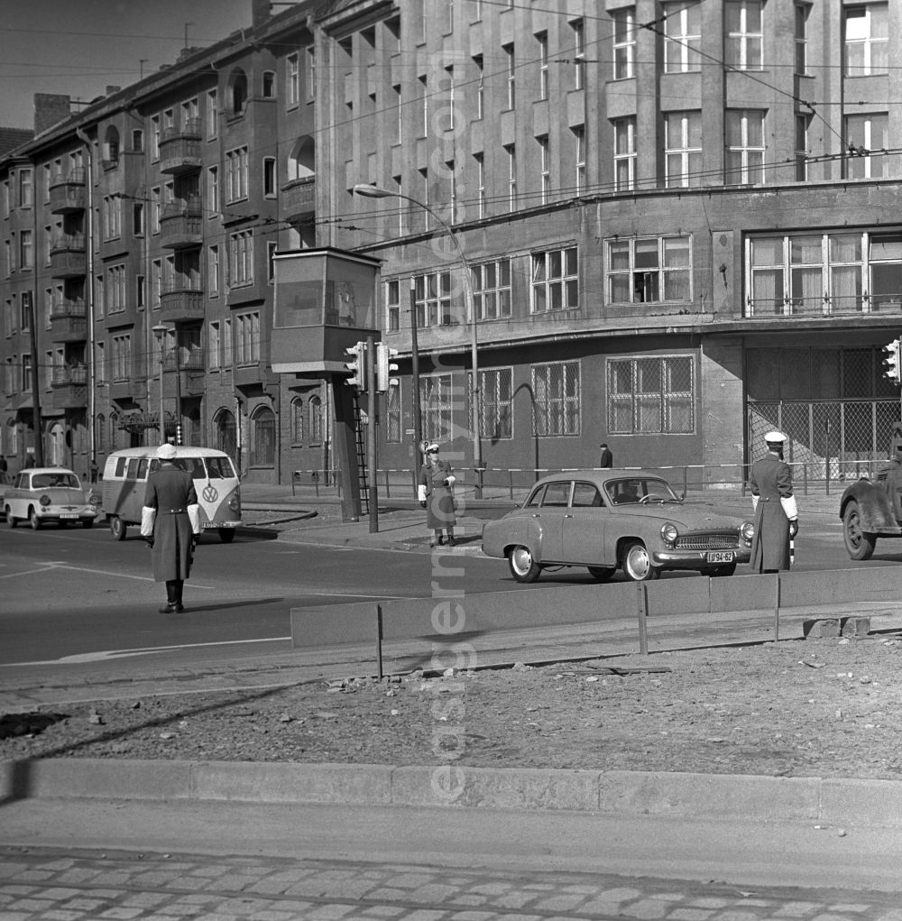 GDR photo archive: Berlin - Mitte - Police officers in the police with white arm warmers in the manual control of road traffic in Berlin - Mitte. The People's Police, colloquially Vopo, in the GDR was the centrally organized police. At some intersections in Berlin there was a solid VP-payer tower, pictured left, on the pavement of the traffic lights were then switched to permanent pasture for the log haul