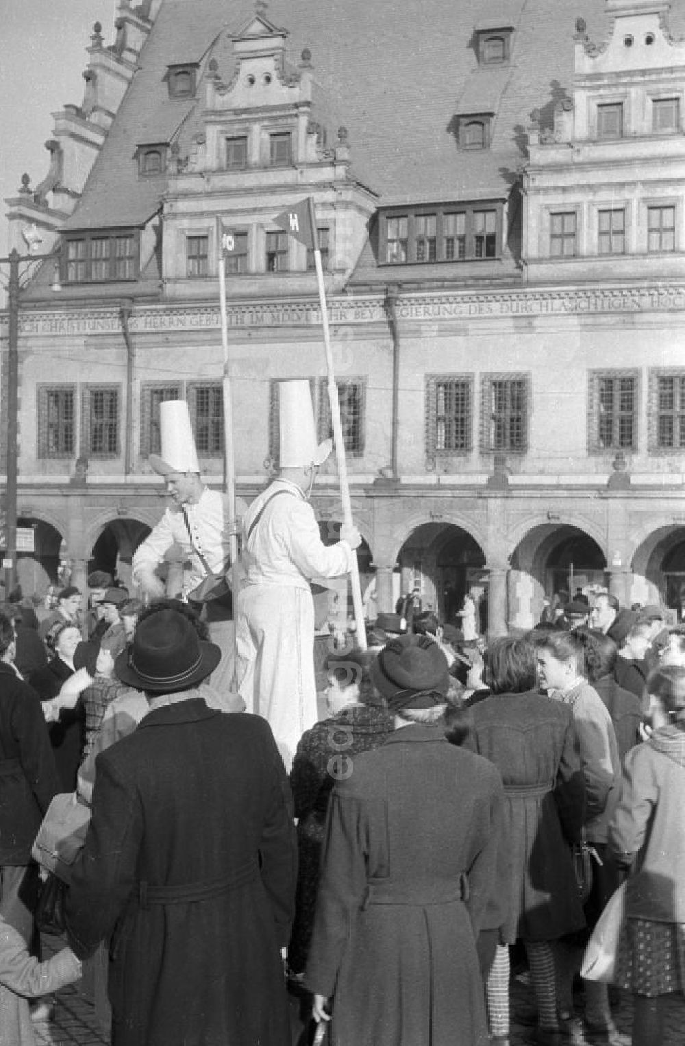 GDR image archive: Leipzig - Zwei Männer als Vertreter der HO / Handelsorganisation machen eine Werbeaktion auf dem Markt in Leipzig. Um die Männer hat sich eine Menschenmenge versammelt. Im Hintergrund ist die Front-Fassade des Alten Rathaus zu sehen. Die HO war ein staatlich geführtes Einzelhandelsunternehmen, welches 1947 gegründet wurde.