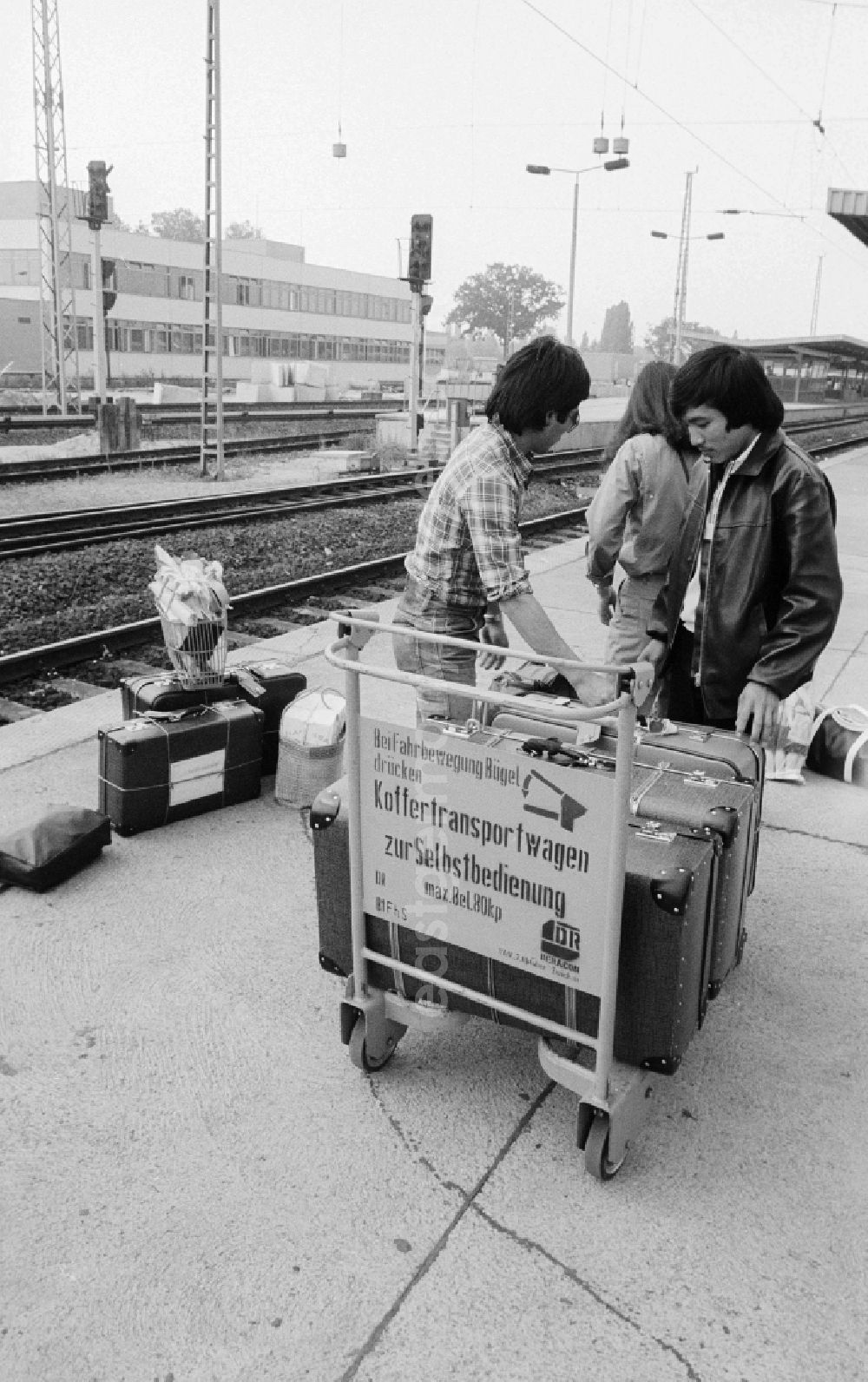 GDR picture archive: Schönefeld - Vietnamese foreign workers by baggage car at the railway station airport Berlin-Schoenefeld in Schoenefeld in the federal state Brandenburg in the area of the former GDR, German democratic republic