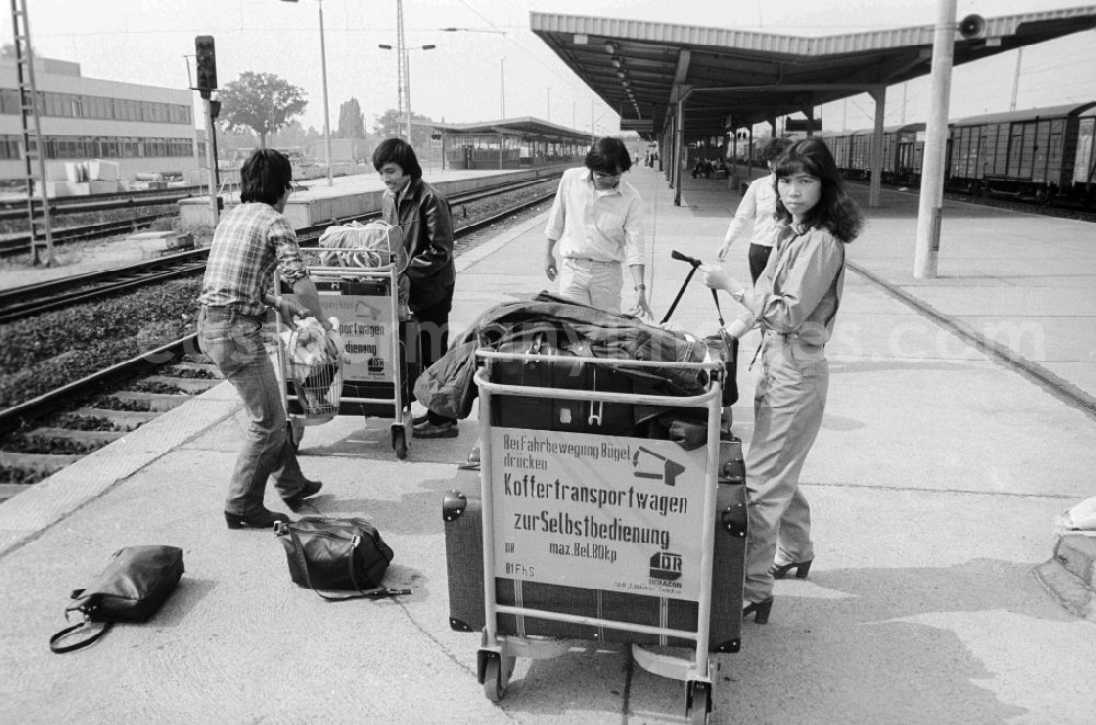 GDR photo archive: Schönefeld - Vietnamese foreign workers by baggage car at the railway station airport Berlin-Schoenefeld in Schoenefeld in the federal state Brandenburg in the area of the former GDR, German democratic republic