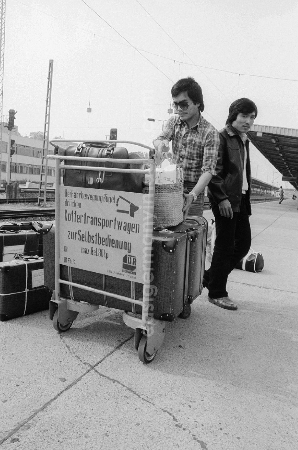 Schönefeld: Vietnamese foreign workers by baggage car at the railway station airport Berlin-Schoenefeld in Schoenefeld in the federal state Brandenburg in the area of the former GDR, German democratic republic