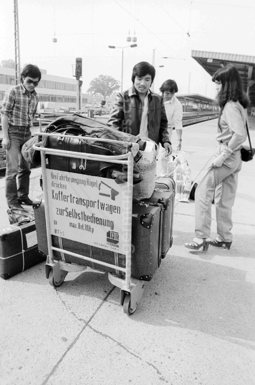 GDR image archive: Schönefeld - Vietnamese foreign workers by baggage car at the railway station airport Berlin-Schoenefeld in Schoenefeld in the federal state Brandenburg in the area of the former GDR, German democratic republic