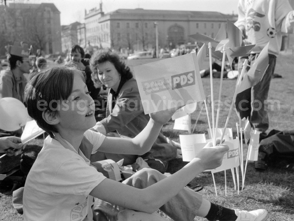 GDR photo archive: Berlin - Supportive member of the Party of Democratic Socialism PDS and children with little flags and windmills on the property before the Haus am Werderschern Markt in Berlin-Mitte, former seat of the Central Committee of the SED and politburo and a former extension of the Reichsbank. Bestmögliche Qualität nach Vorlage!
