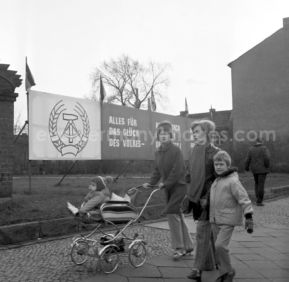 GDR photo archive: Berlin - Zwei Mütter mit ihren Kindern laufen an einem Transparent mit Wahlkampfmotiven vorbei. Am 14. November finden die Wahlen zur Volkskammer der DDR und zu den Bezirkstagen statt.